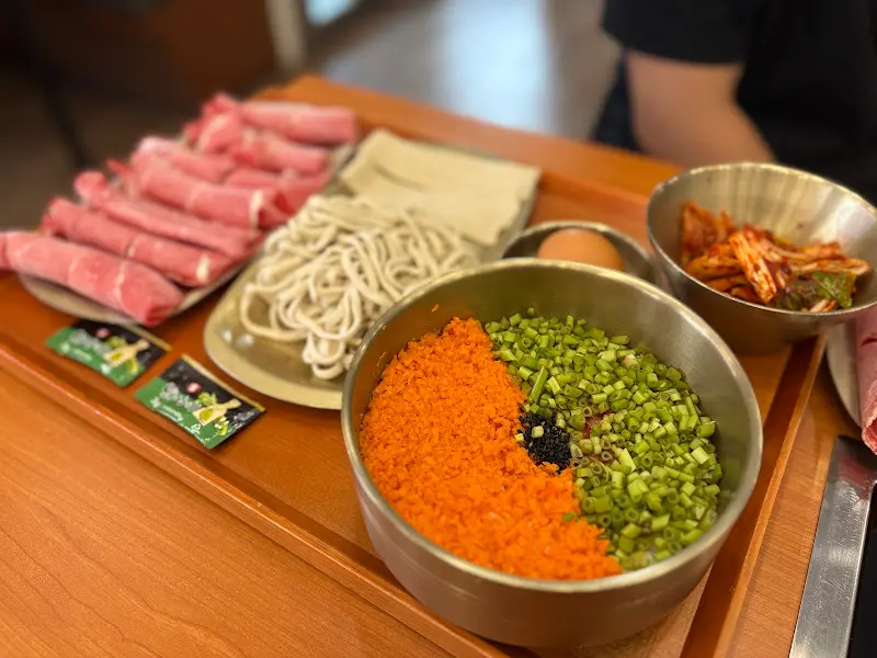 샤브샤브 재료와 칼국수 면, 김치가 담긴 쟁반