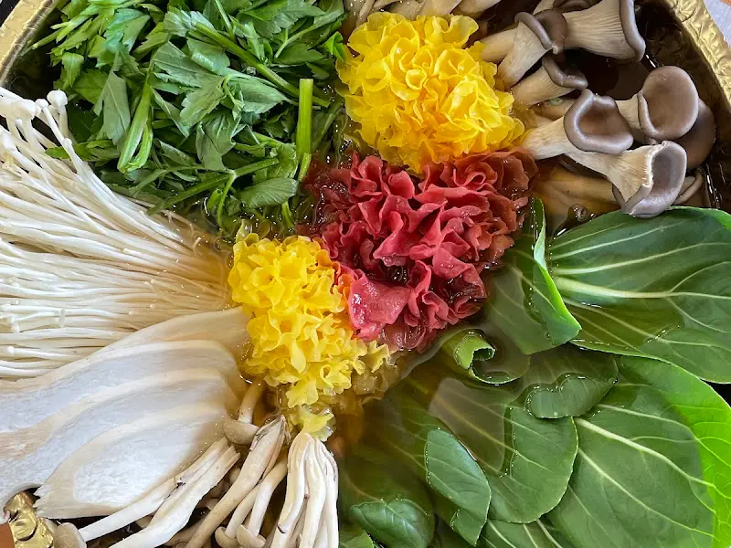 샤브샤브 냄비에 담긴 다채로운 채소와 버섯