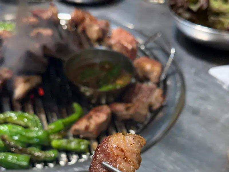 잘 구워진 주먹고기를 멜젓에 찍어 먹는 모습