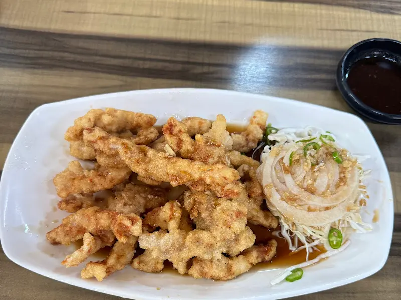 윤기가 자르르 흐르는 고기 튀김과 양파 슬라이스, 할라피뇨가 함께 담겨 나온 모습