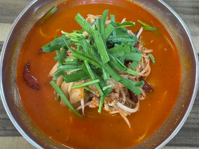 해장짬뽕의 붉은 국물 위에 숙주와 부추, 태국 고추가 수북이 쌓여 있는 모습