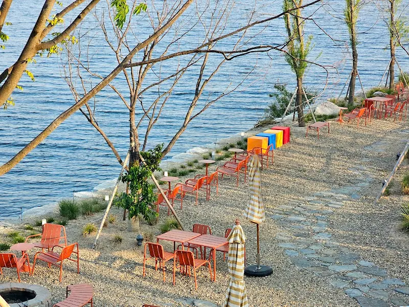 강변을 따라 놓인 야외 테이블과 의자들