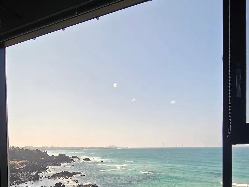 넓은 창 너머로 펼쳐지는 푸른 제주 바다