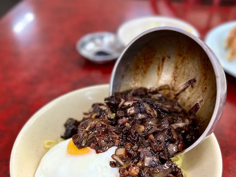 간짜장 소스를 면에 붓는 모습