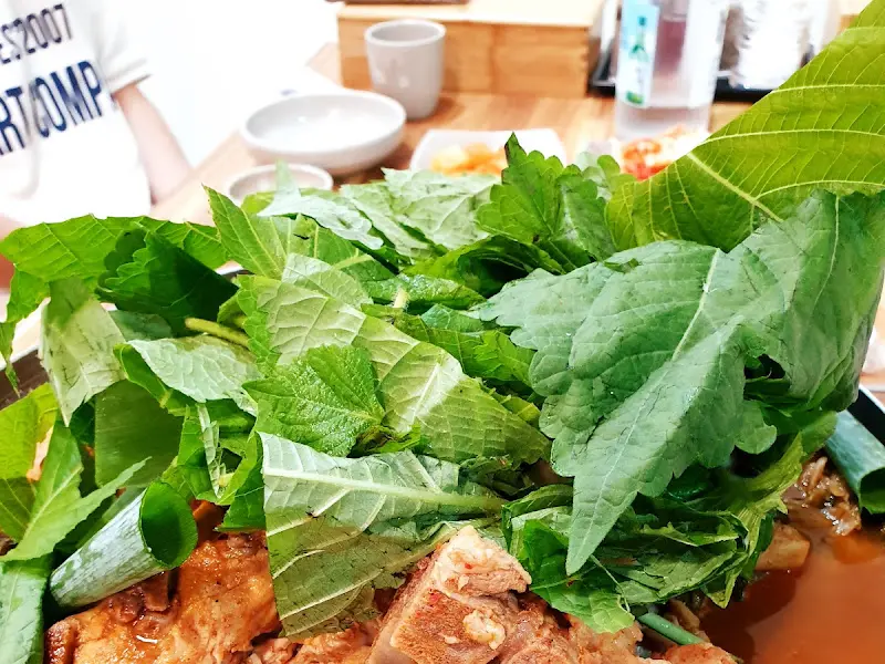 푸짐하게 쌓인 감자탕 위 채소