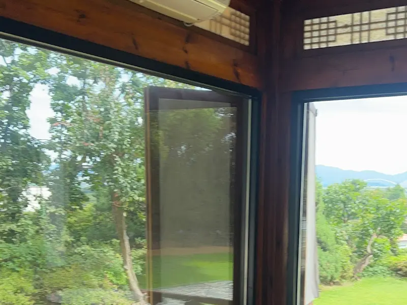 한옥 창문 너머로 보이는 푸르른 풍경