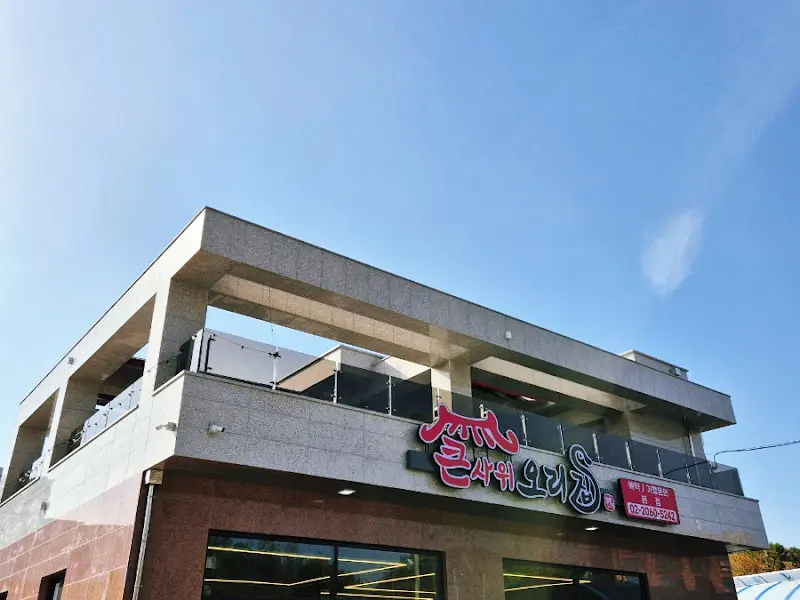 밝은 하늘 아래 우뚝 솟은 큰사위 오리집