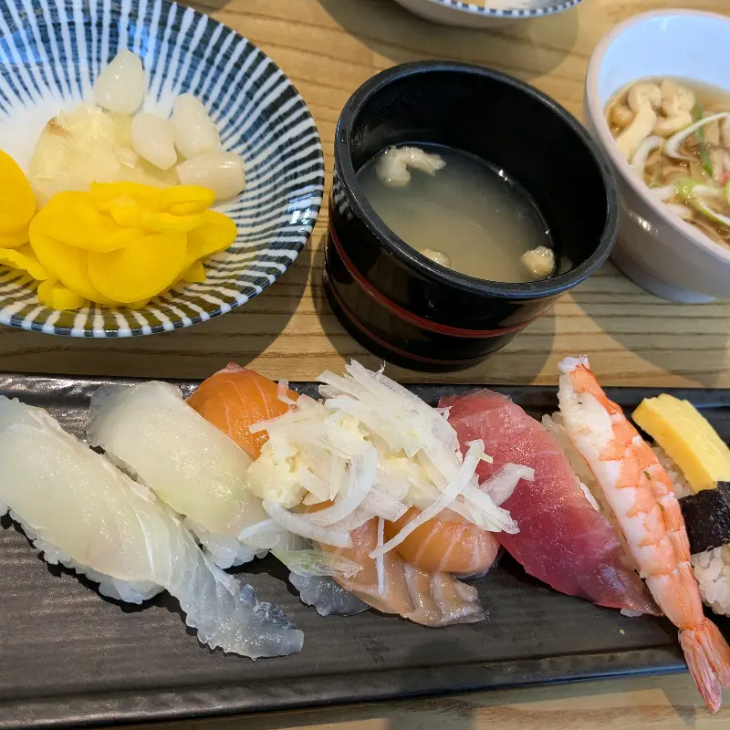 다양한 곁들임 반찬과 신선한 초밥이 조화로운 상무초밥