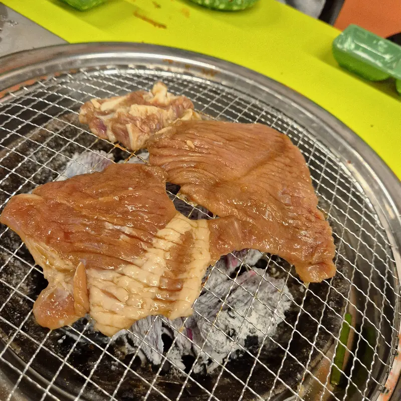 숯불 위에서 돼지갈비가 익어가는 모습