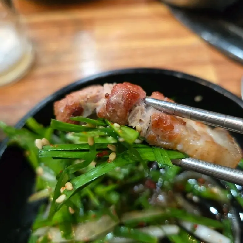 오겹살과 부추무침을 함께 먹는 모습