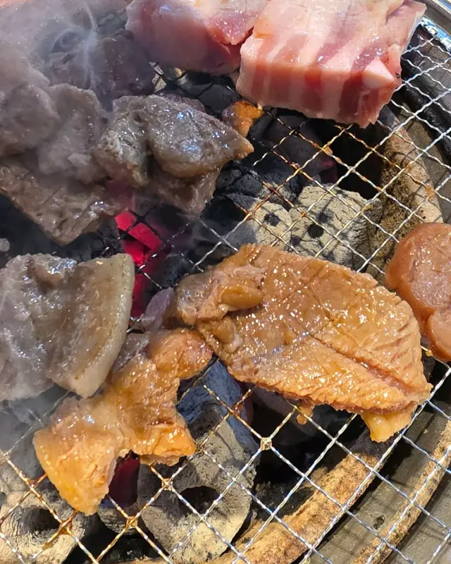 숯불 위에서 익어가는 돼지갈비와 삼겹살