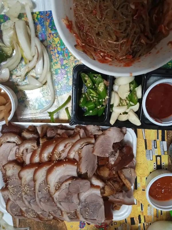 족발, 막국수, 쌈 채소가 함께 차려진 상차림 사진