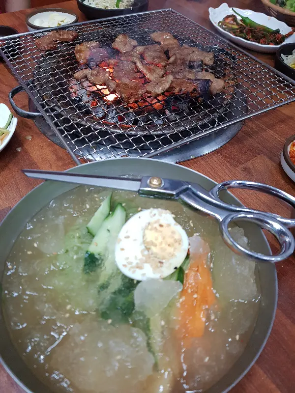 숯불 위에서 익어가는 왕갈비와 물냉면