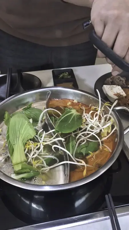 얼큰 육수에 야채를 넣는 모습