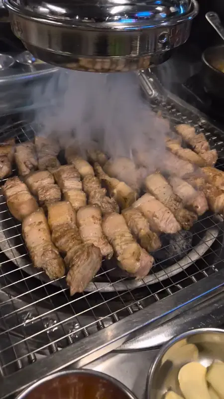 초벌되어 나온 오겹살이 숯불 위에서 맛있게 익어가는 모습