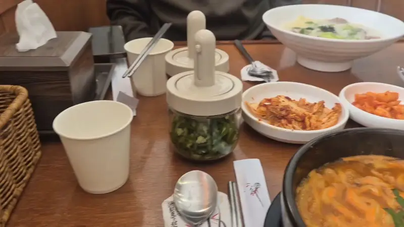 테이블 위에 놓인 고기국수, 김치, 깍두기