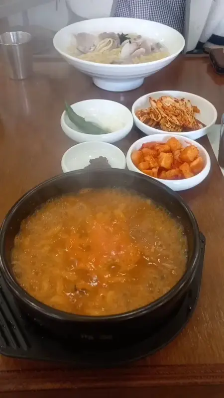 테이블 위에 놓인 고기국수와 뚝배기에 담긴 어탕칼국수