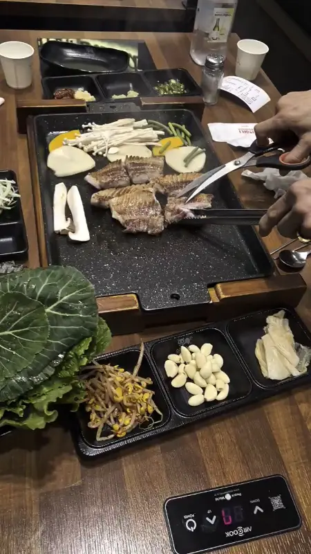 불판 위에서 익어가는 삼겹살과 버섯