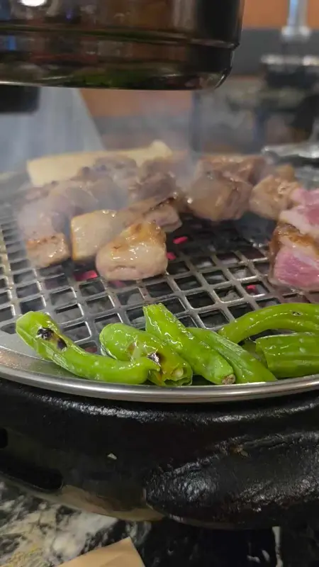 불판 위에서 맛있게 익어가는 등겹살과 꽈리고추