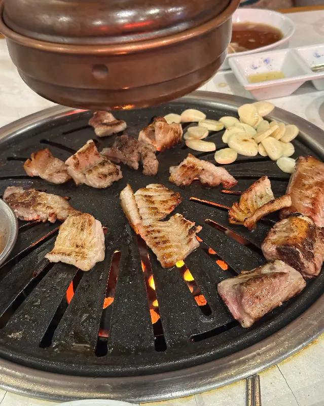 불판 위에서 익어가는 고기와 마늘