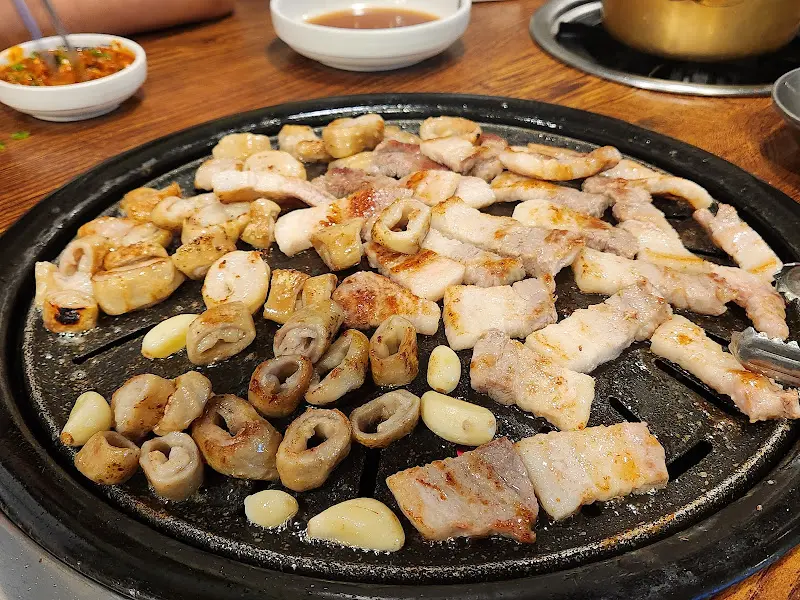 잘 구워진 삼겹살과 꽂살, 마늘이 함께 올려진 불판