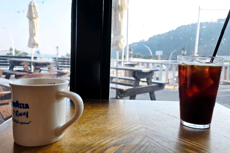 창밖의 바다 풍경과 함께 놓인 커피