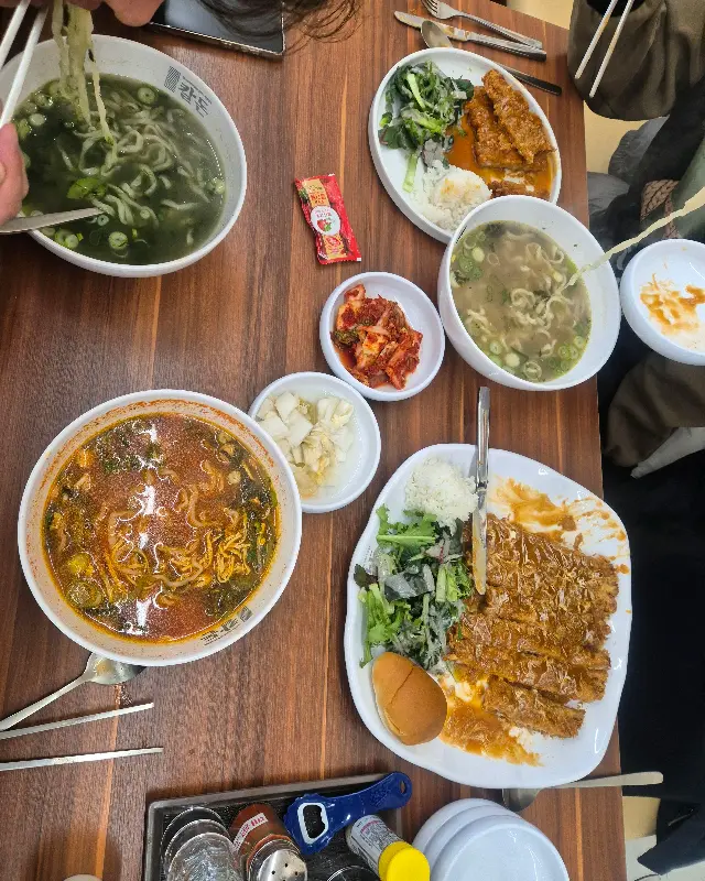 테이블 가득 차려진 칼국수와 돈까스 세트 메뉴