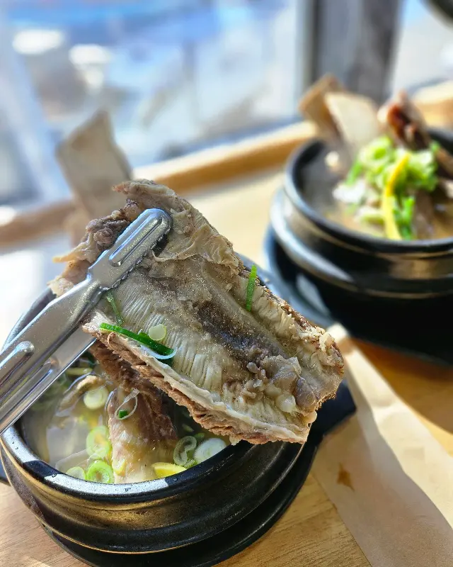 집게로 갈비를 들어 올리는 모습