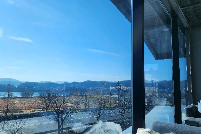 통창으로 보이는 낙동강 뷰. 파란 하늘과 강물이 어우러져 시원한 느낌을 준다.