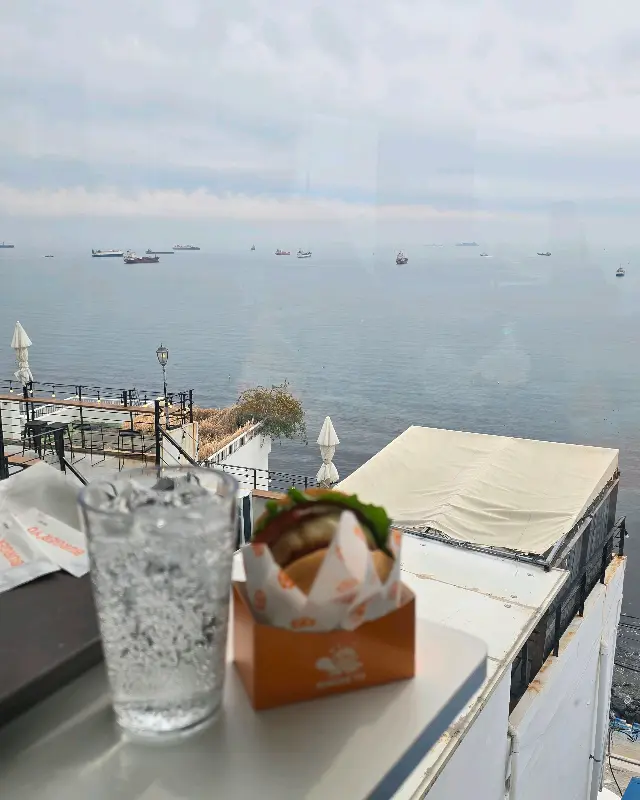 푸른 바다를 배경으로 즐기는 버거와 음료