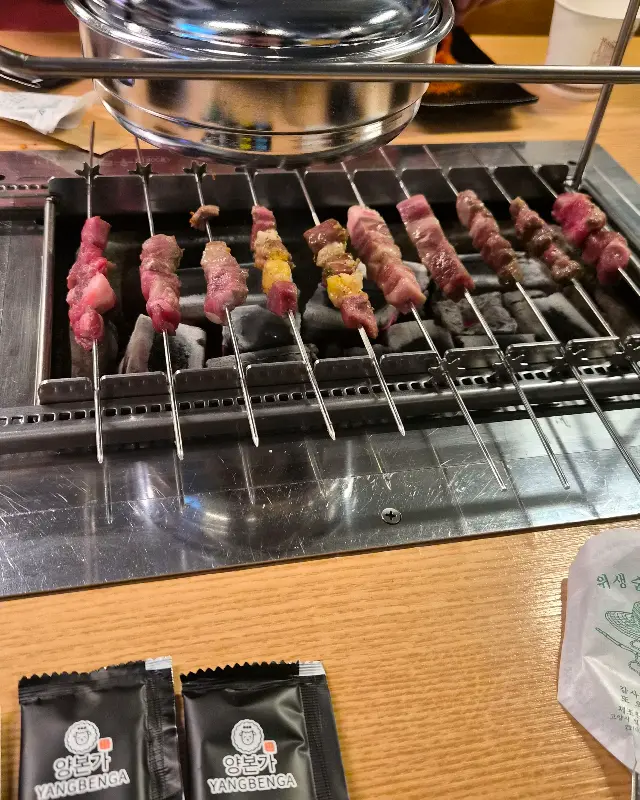 숯불 위에서 맛있게 익어가는 다양한 종류의 꼬치들