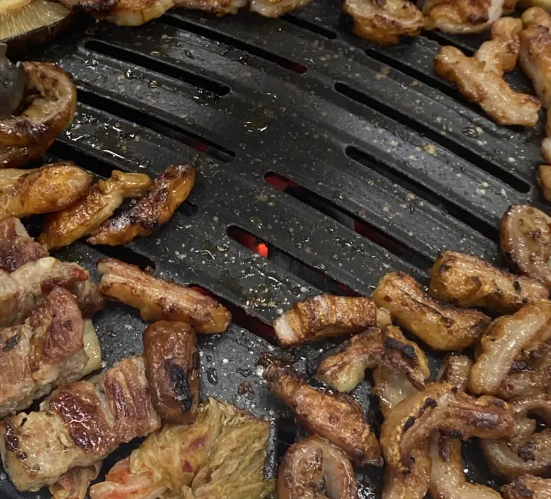 불판 위에서 노릇하게 익어가는 막창과 삼겹살