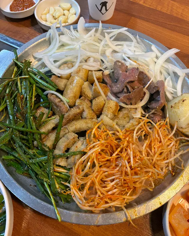 모듬 곱창 한 상 차림. 곱창, 대창, 염통, 막창과 다양한 야채들이 푸짐하게 담겨 있다.