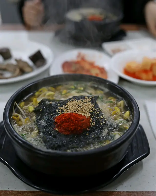 김 가루와 고춧가루가 듬뿍 뿌려진 콩나물국밥