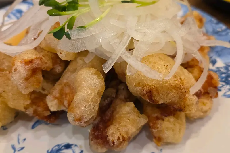 양파 슬라이스와 함께 튀김옷이 바삭하게 튀겨진 탕수육