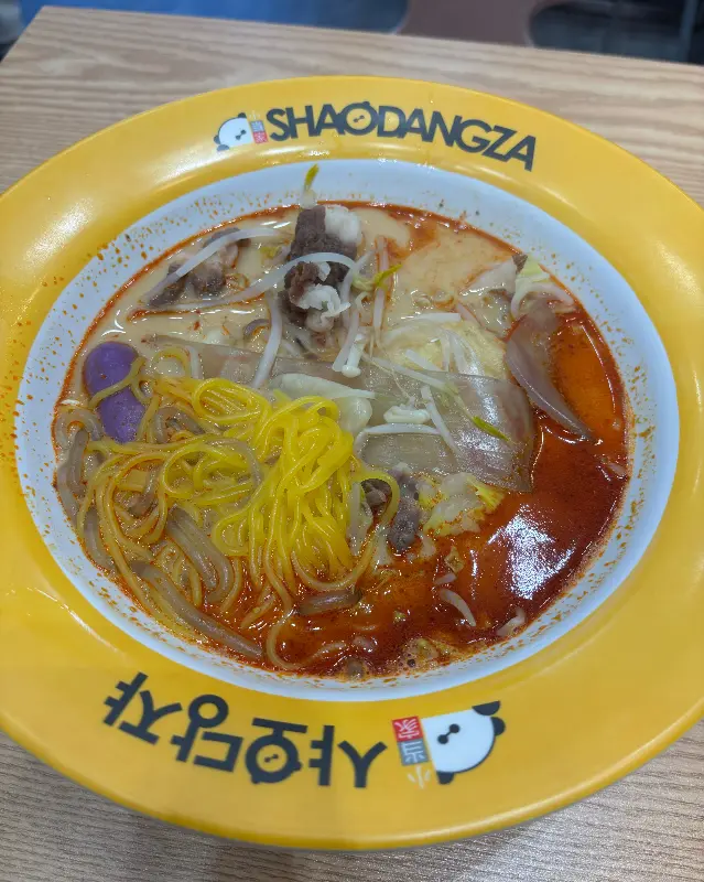 노란색 그릇에 담긴 마라탕. 면, 채소, 꼬치 등 다양한 재료가 푸짐하게 들어 있다.