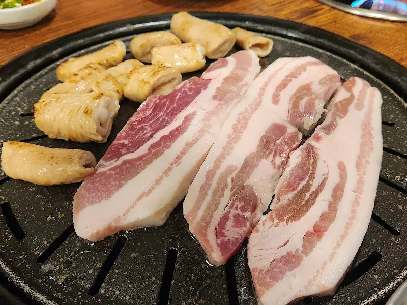 불판 위에 올려진 신선한 삼겹살과 꽂살