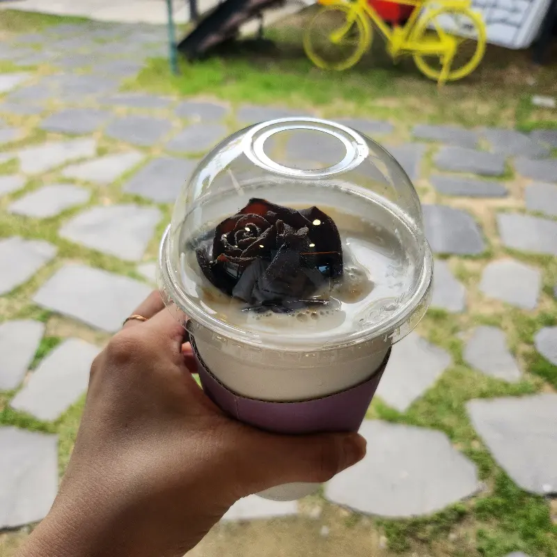 독특한 비주얼의 음료: 투명 컵 안에 담긴 음료 위에 검은색 장식이 눈길을 사로잡는다.