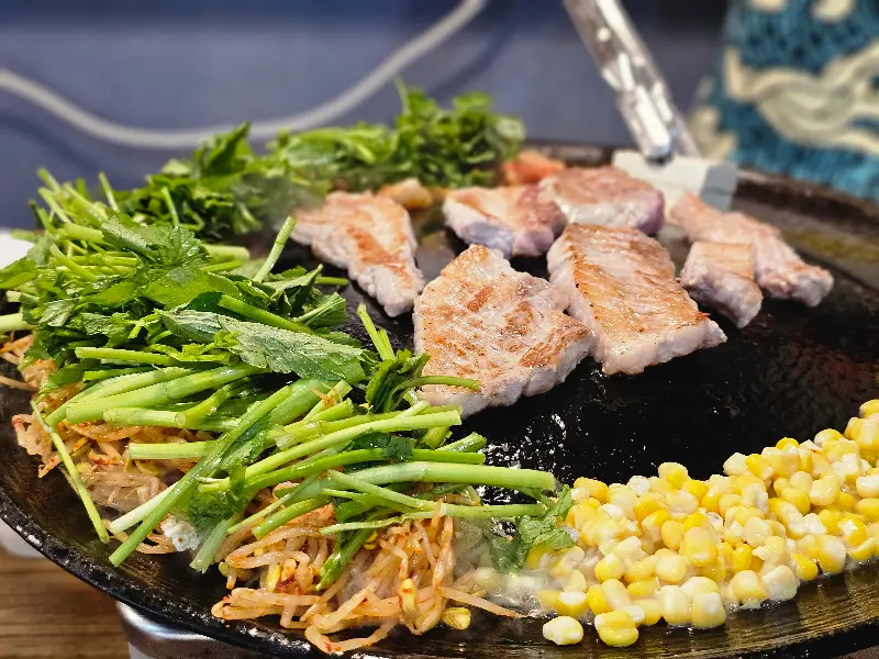 김치, 콩나물, 미나리가 곁들여진 삼겹살