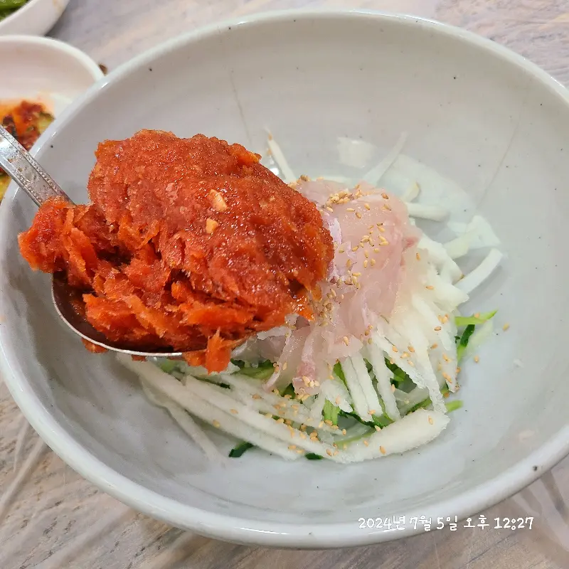 물회에 양념장을 넣는 모습