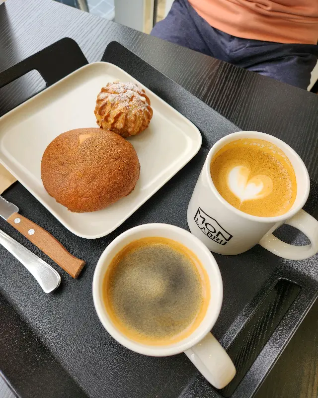 테이블 위에 놓인 커피 두 잔과 빵