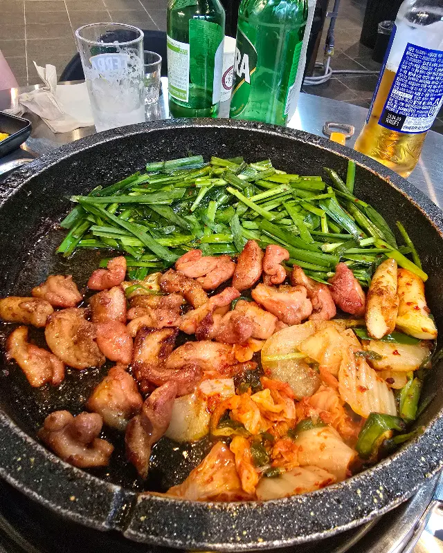 불판 위에 익어가는 곱창과 김치, 부추의 조화