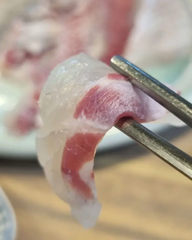 젓가락으로 집어 올린 회 한 점