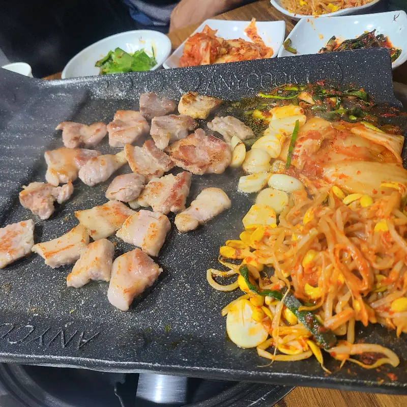 삼겹살과 김치, 콩나물을 함께 구워 먹는 모습