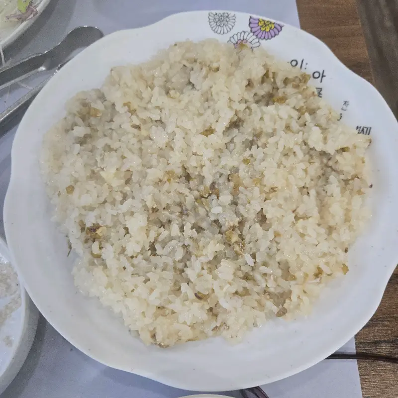 찰밥으로 만든 죽에 김치를 올려 먹는 모습