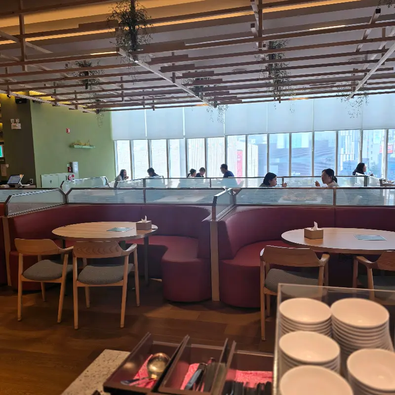 테이블 좌석과 창밖 풍경이 보이는 홀 내부의 모습