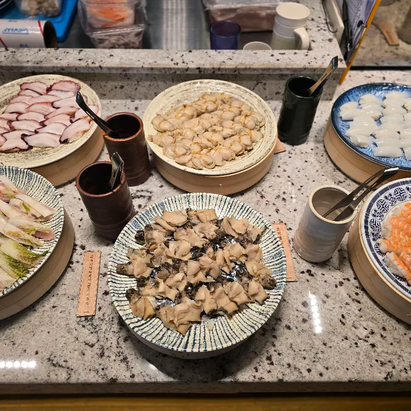 다양한 종류의 신선한 초밥 재료들이 담긴 접시들의 모습