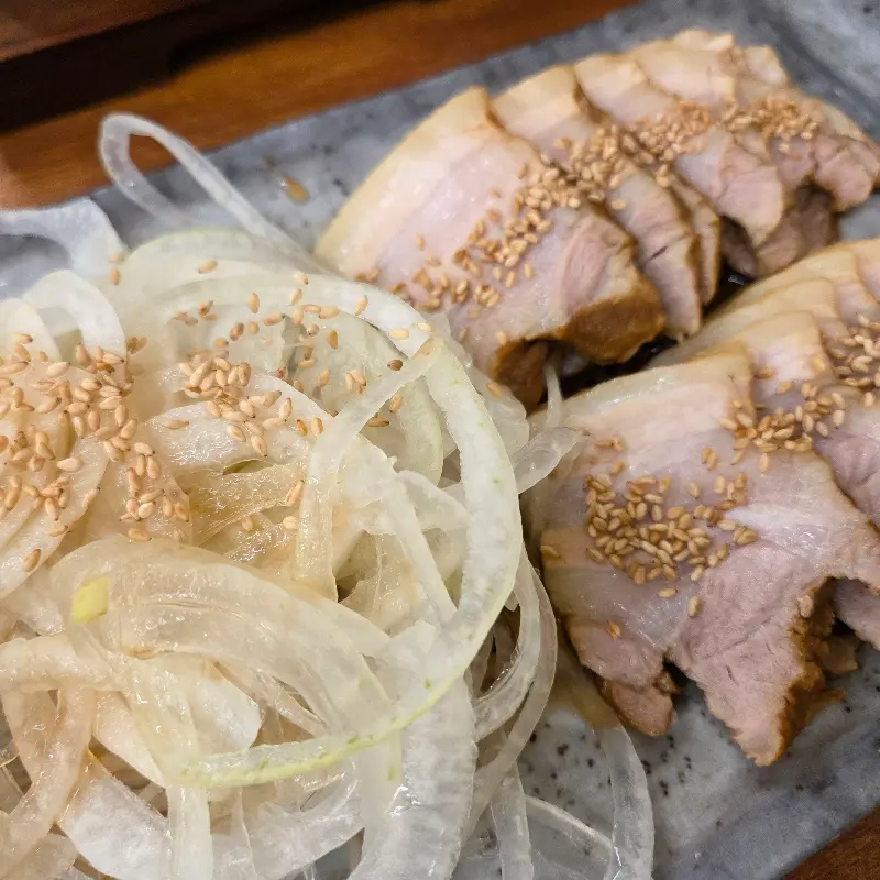 윤기가 흐르는 보쌈과 신선한 양파의 조화