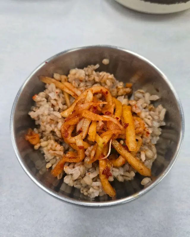 갓 지은 보리밥에 양념된 무생채가 올려진 모습