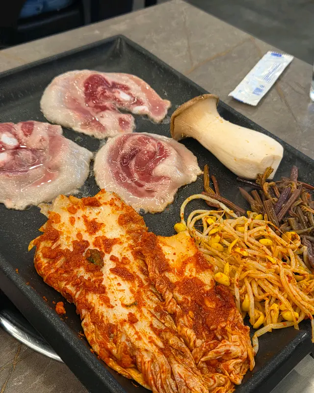 불판 위의 삼겹살과 김치